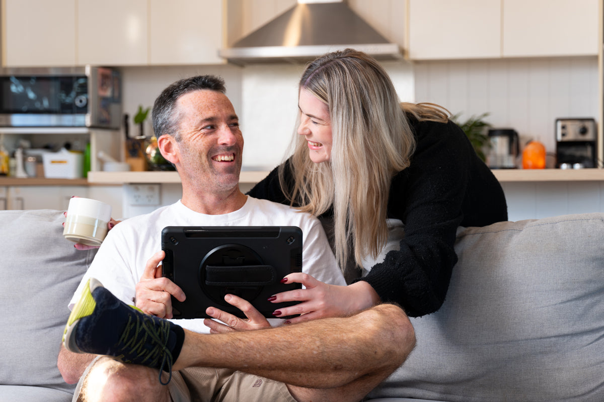 happy_couple_purchasing_steel_online_from_home_sofa_using_tablet