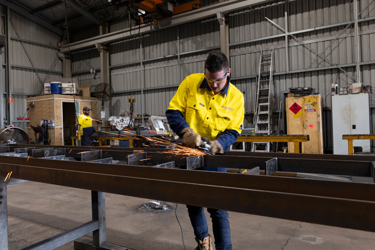 steel-grinding-sparks-flying-in-warehouse-full-PPE-worn